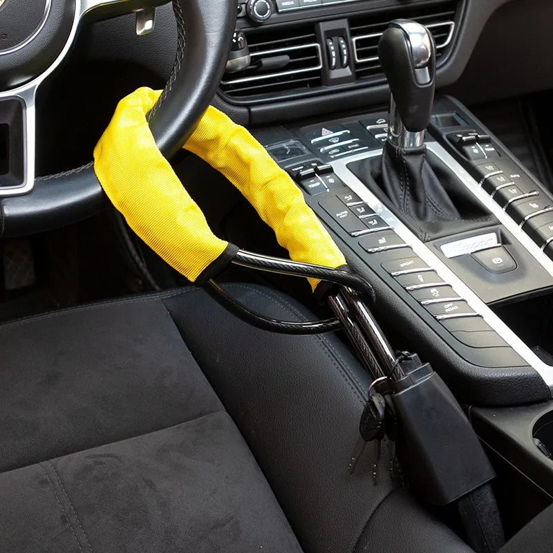 A yellow universal steering wheel and seatbelt lock mechanism is shown in the interior of a car.