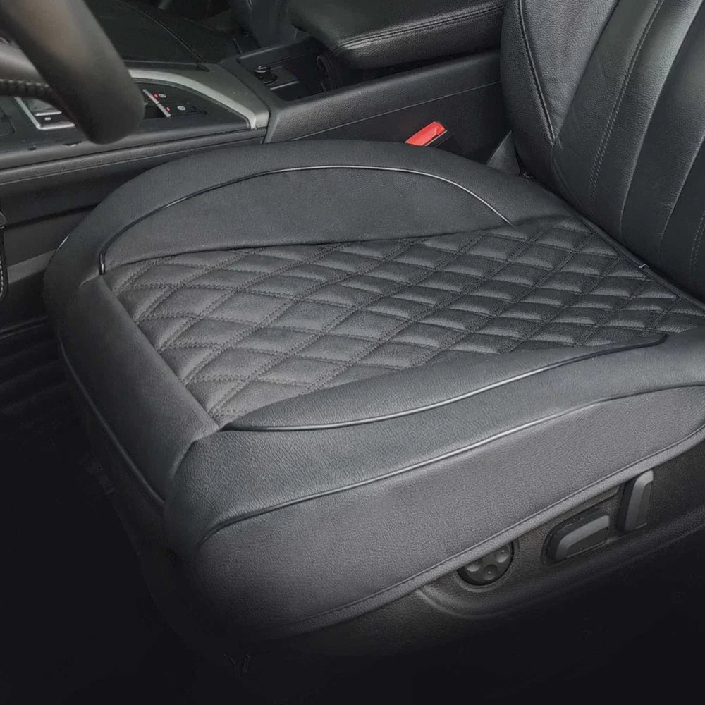A close-up view of a black PU leather car seat cover for a driver's seat, featuring diamond stitching.