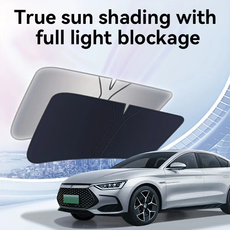 A black heavy-duty portable car sunshade is shown blocking sunlight on a silver sedan.