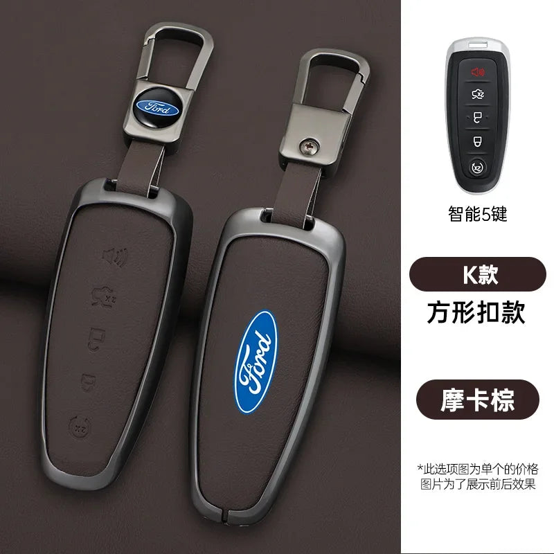 Two dark brown car key covers with Ford logos and a remote control are shown on a dark surface.
