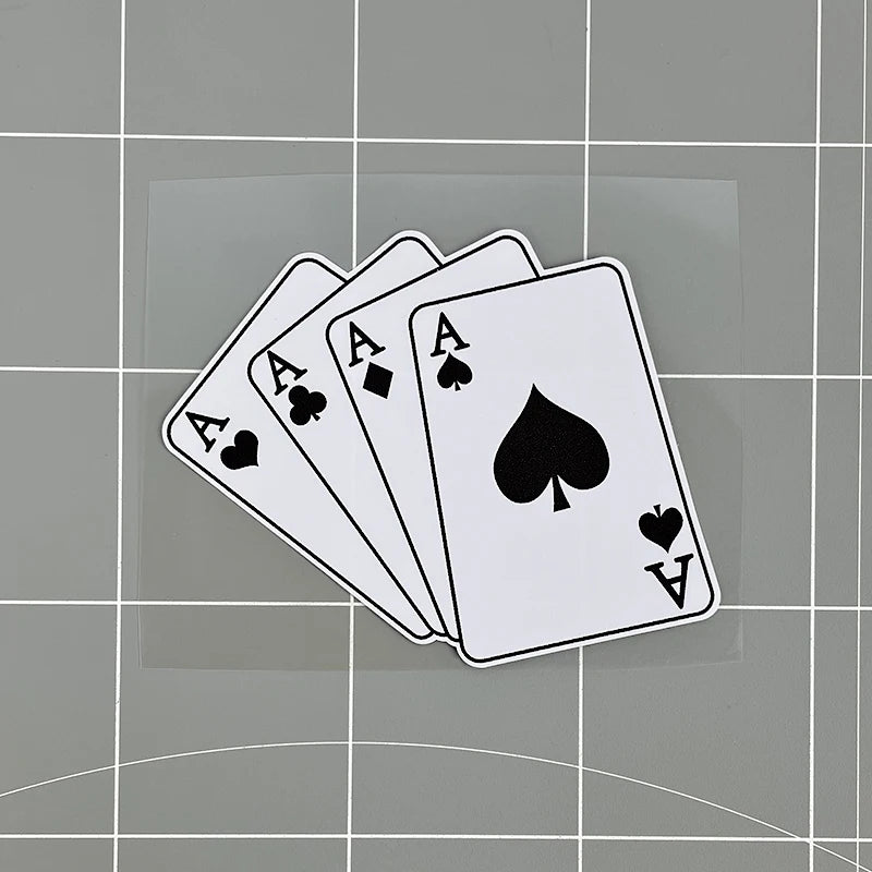 A stack of playing cards showing three aces and a spade on a gray background.