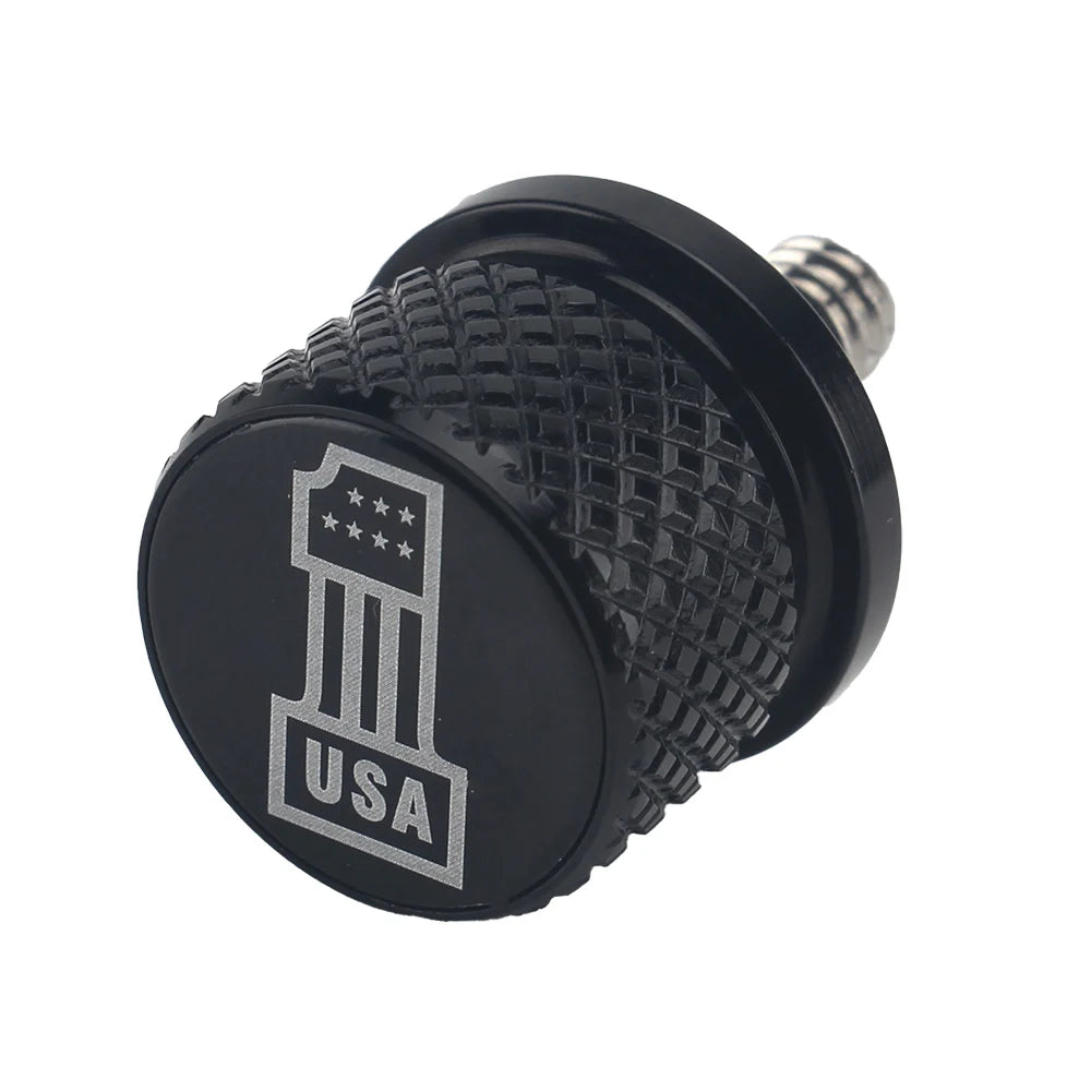 Black aftermarket motorcycle seat and fender bolts with a USA design etched on the surface