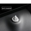 A close-up shot of a white diamond car door lock pin trim set resting on a dark leather surface.