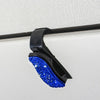 Schwarzer Halter für Sonnenbrillen mit leuchtend blauer Kristallakzent.