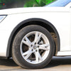 Close-up of a white car wheel with carbon fiber trim installed on the fender arch.