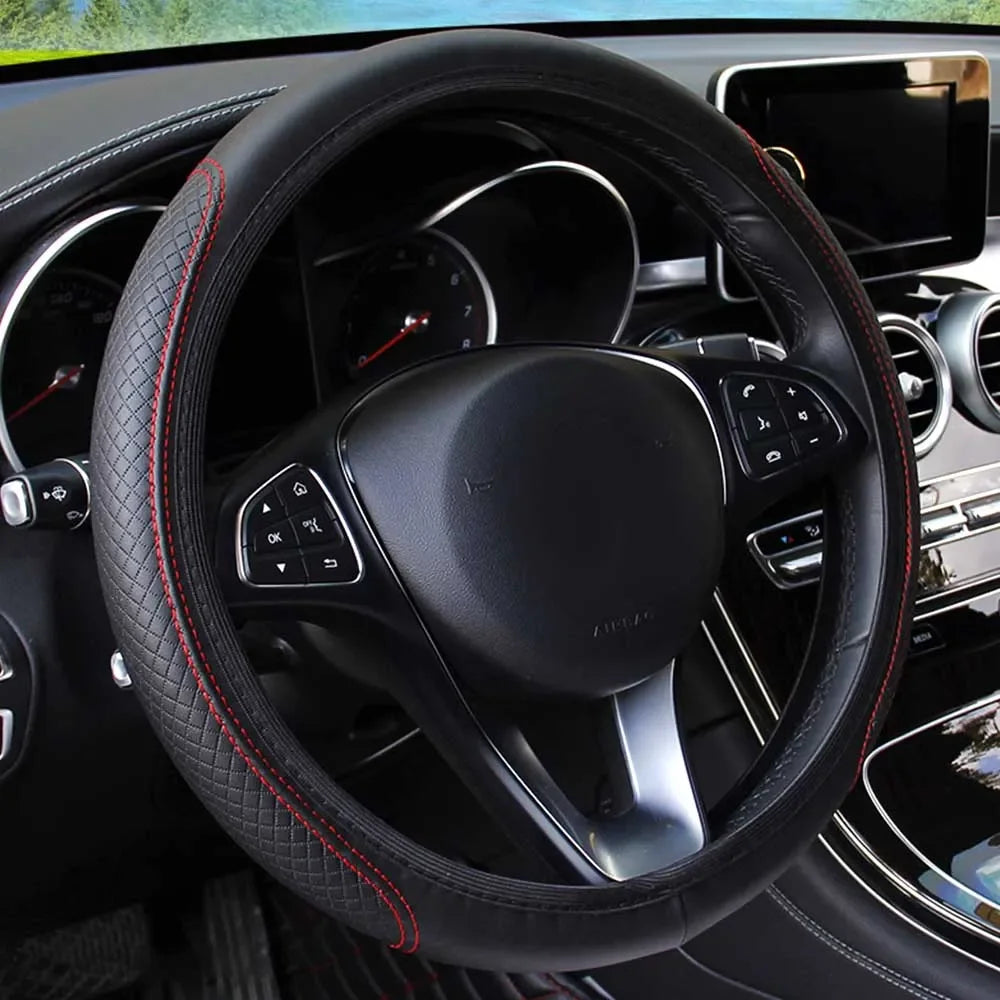 Close-up view of a black leather steering wheel with red stitching inside a car interior.