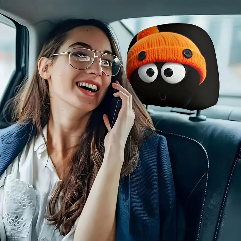 Une femme utilise un téléphone dans une voiture, avec une housse décorative en tricot orange et noir pour le dossier de siège