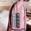 Pink backpack with a zipper pouch containing multiple clear LED keyboard keychains