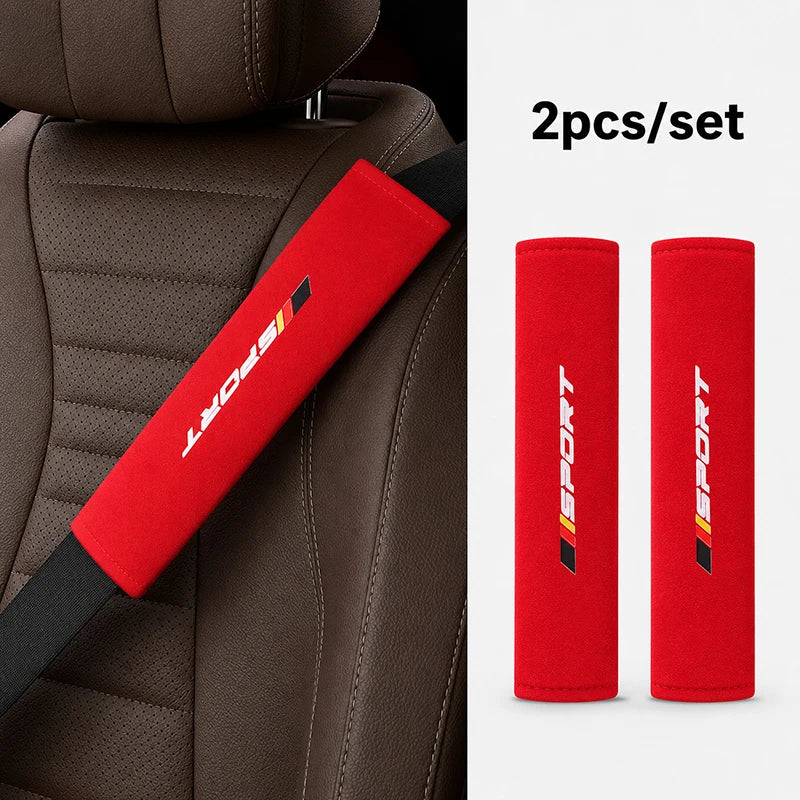 Two red sports shoulder pads for a car seat belt set shown against a brown leather seat.