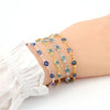 Gold plated evil eye charm bracelet featuring blue and green stones on an adjustable link chain