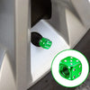 Close-up of a green aluminum dice valve cap installed on a tire valve stem.