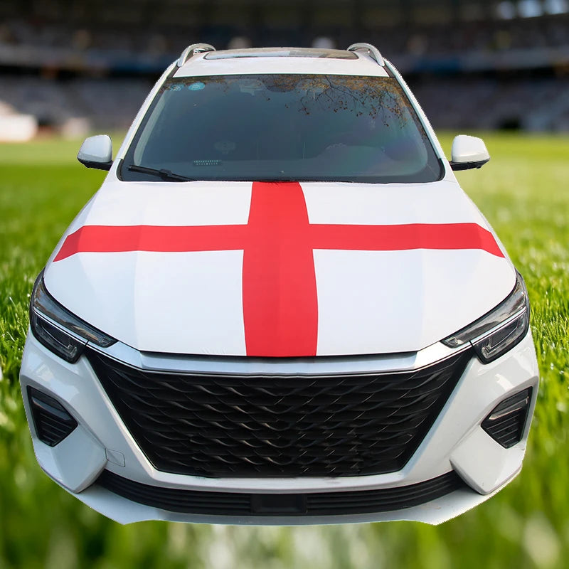 A white car with a red St. George's cross flag decoration on the hood, parked on green grass.