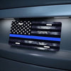 A decorative aluminum flag sign featuring the American flag design with a blue stripe and stars mounted on a dark gray surfac
