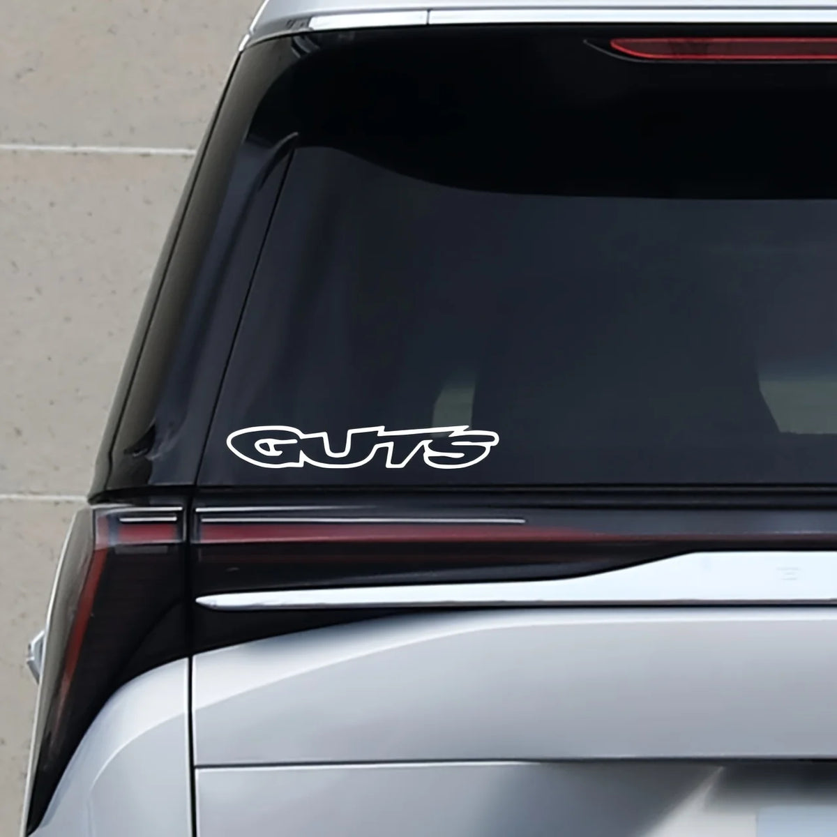 Close-up of a dark vehicle window showing a white GTS decal on the lower trim and reflection.