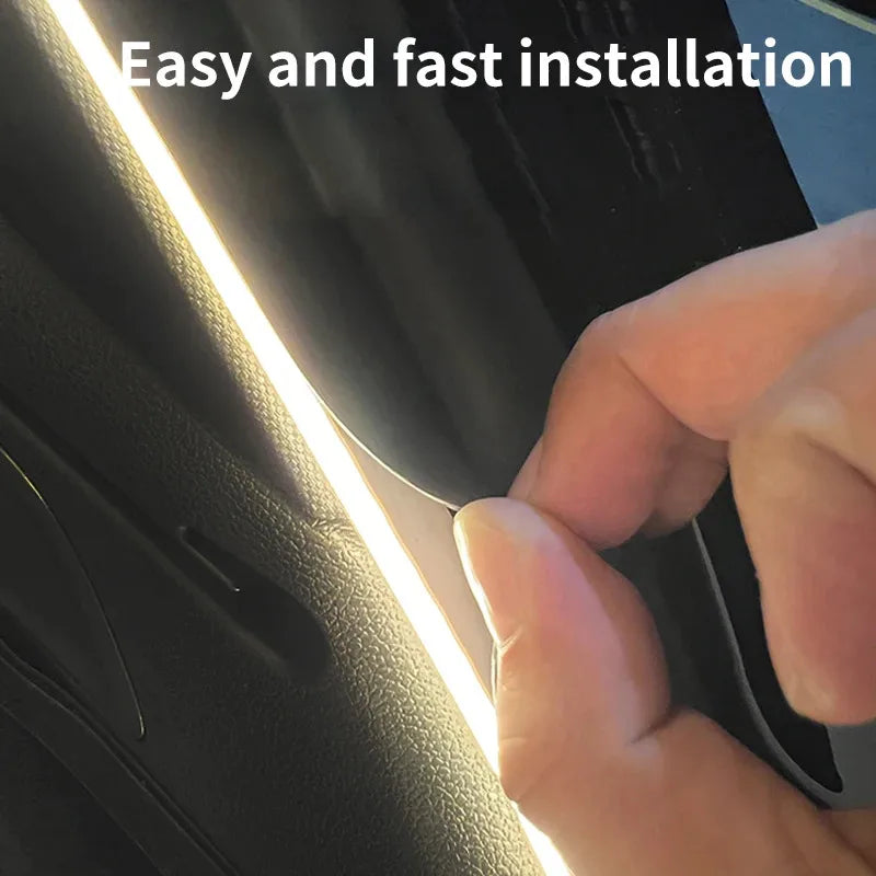 Une main installe une bande lumineuse LED brillante dans le garnissage intérieur d'un coffre de voiture.