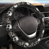 Volant noir avec motif crâne et rose installé dans l'habitacle d'une voiture.