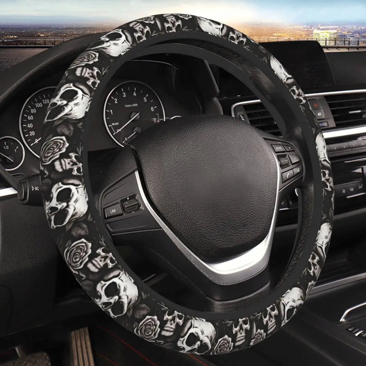 Volant noir avec motif crâne et rose installé dans l'habitacle d'une voiture.