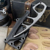 A durable stainless steel fixed blade survival knife is shown resting on a tan fabric with various knife components.