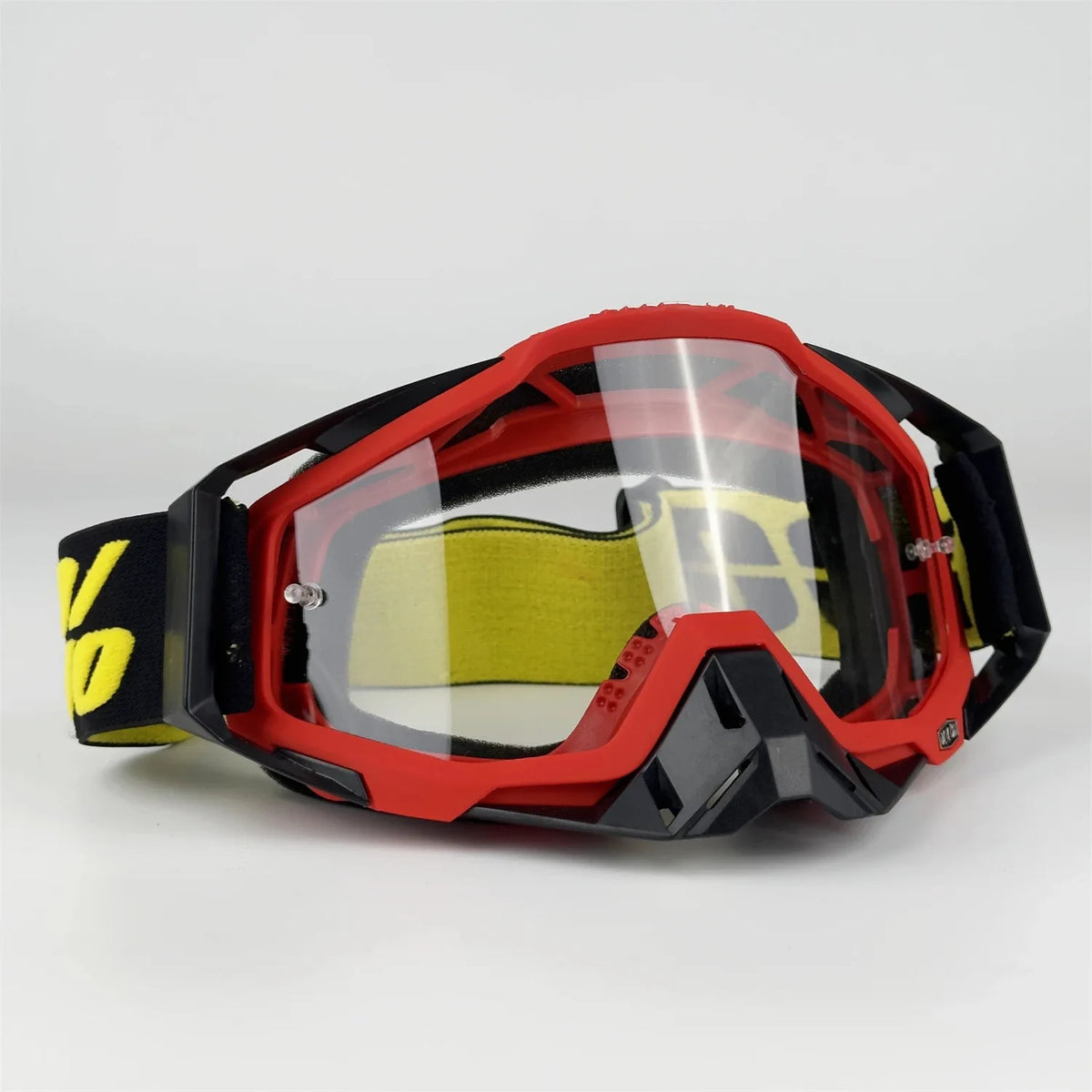 A pair of red and black off-road motorcycle riding goggles with a yellow lens and strap.