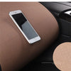 A silver smartphone rests on a brown car seat cushion.