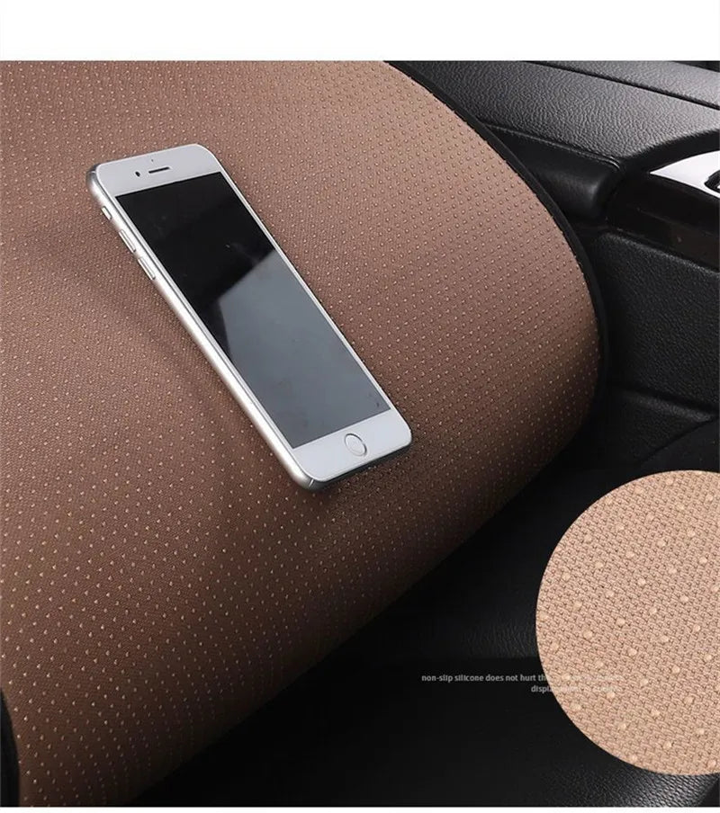 A silver smartphone rests on a brown car seat cushion.