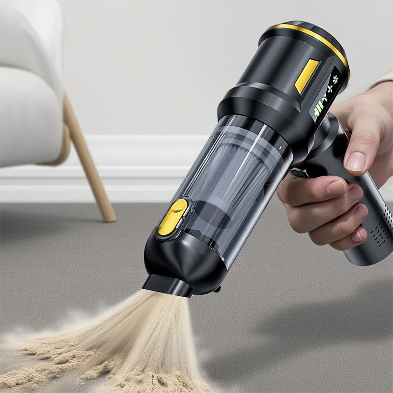 A hand is using a black cordless handheld car vacuum cleaner to clean a light gray floor.