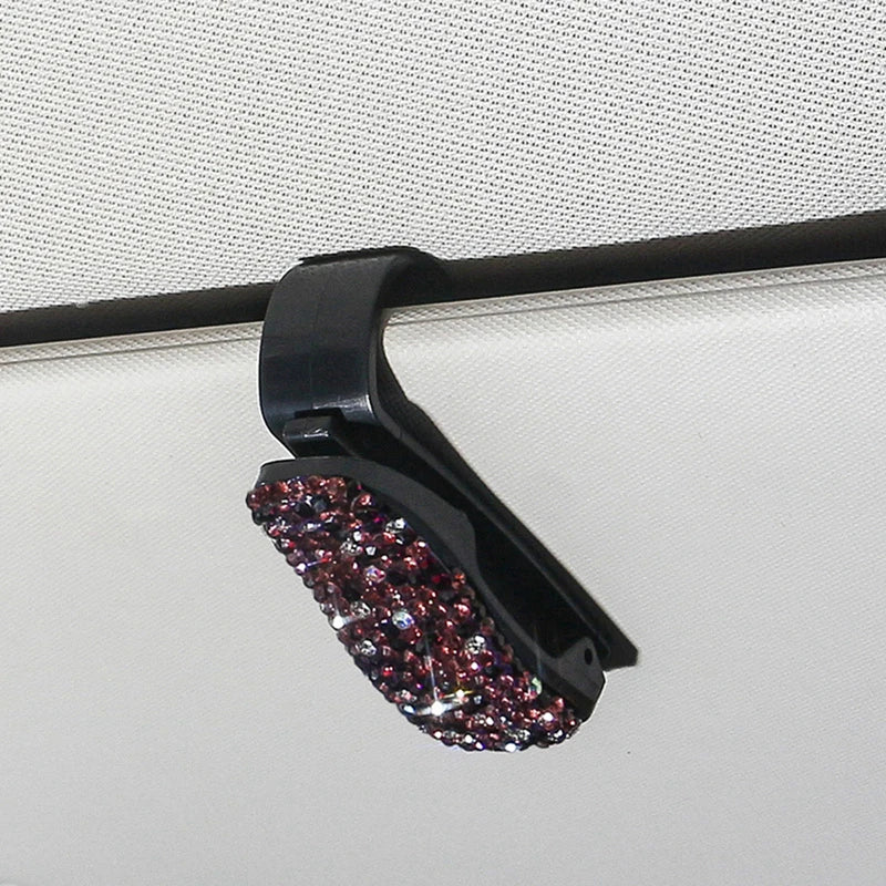 Schwarzer Halter für Sonnenbrillen mit dekorativem Akzent aus violetten und rosa Kristallen.