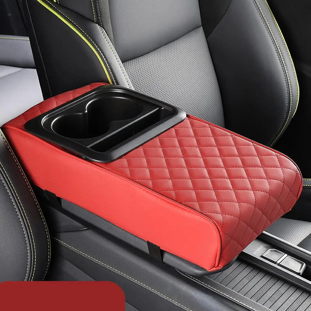 A red quilted car armrest cushion with an integrated cup holder is shown in a vehicle interior.