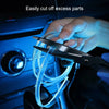 A hand uses a pair of scissors to cut excess parts of a flexible blue LED light strip for car interior decoration.