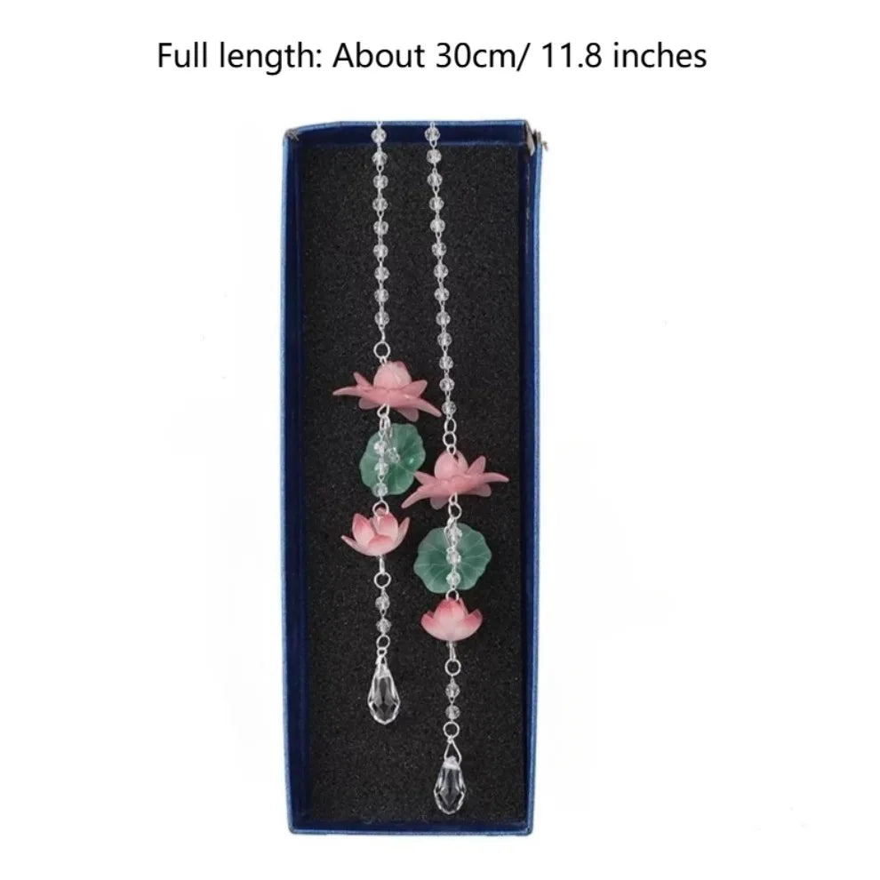 A long silver chain featuring pink lotus-shaped pendants on a dark blue background.