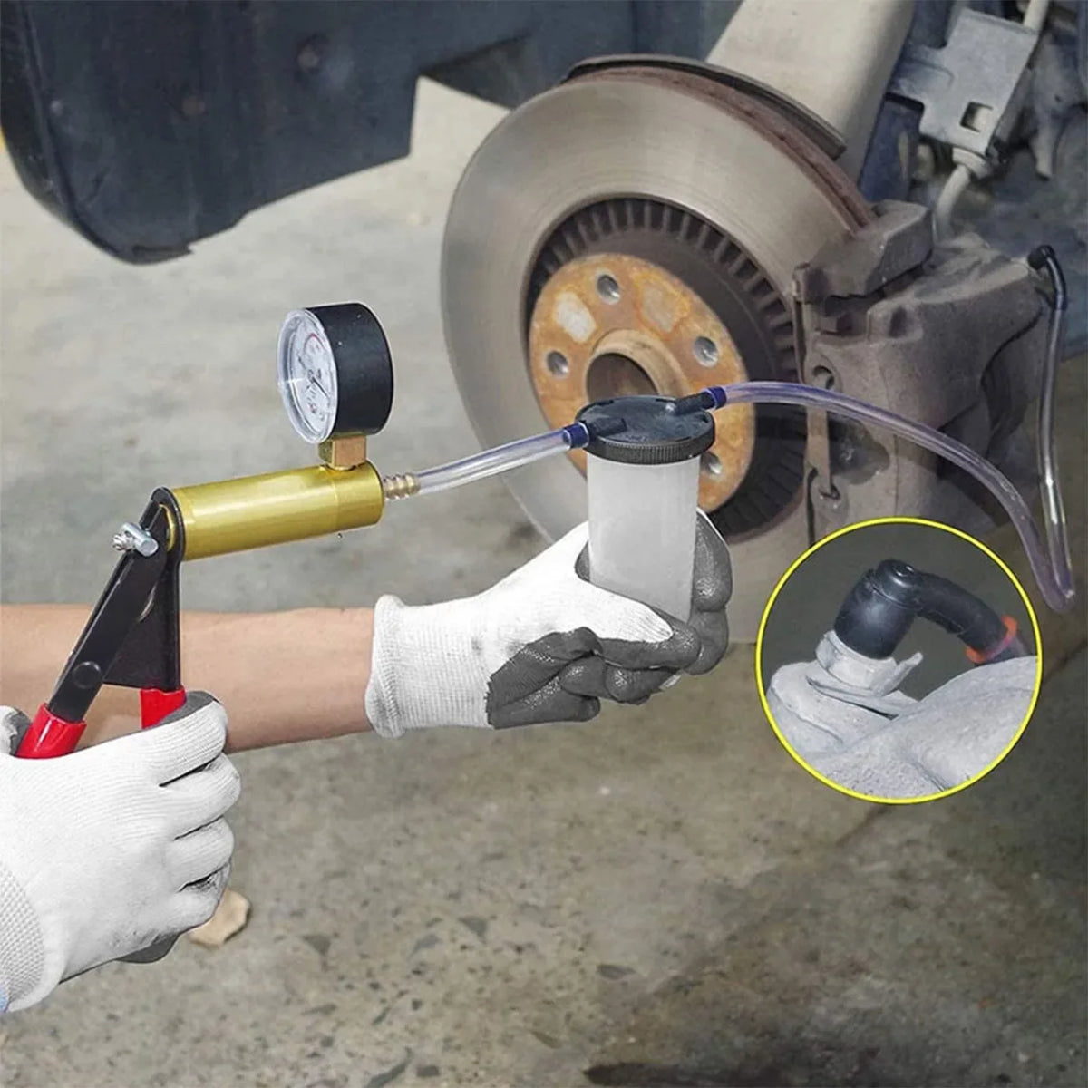 A hand uses a manual vacuum pump and hose to bleed brakes on a bicycle wheel.