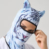 Una persona usando una máscara balaclava con cara de tigre azul claro y negro.