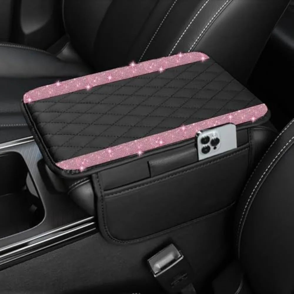A black car console cover with a diamond grid pattern and a pink glitter trim, featuring a smartphone holder.