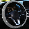 Close-up of a black steering wheel with a crystal diamond rhinestone cover inside a car interior.