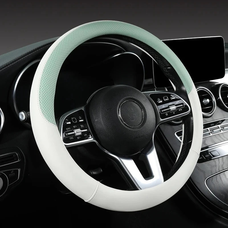 A close-up view of a light green perforated leather steering wheel cover inside a car interior.