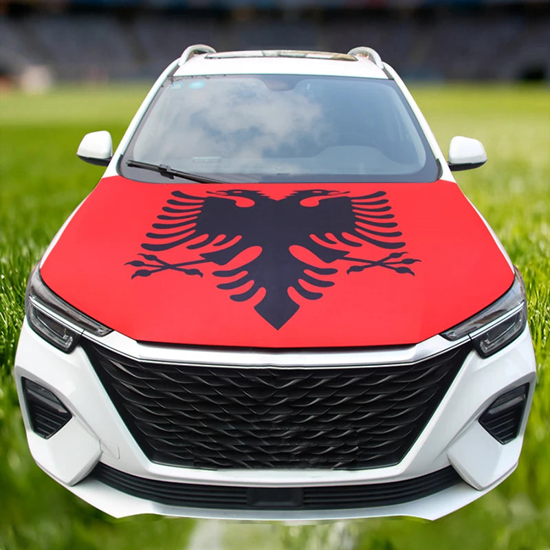 A white car hood decorated with a red flag featuring a black stylized eagle design.