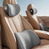 A beige ergonomic memory foam neck and lumbar pillow set shown in a car seat interior.