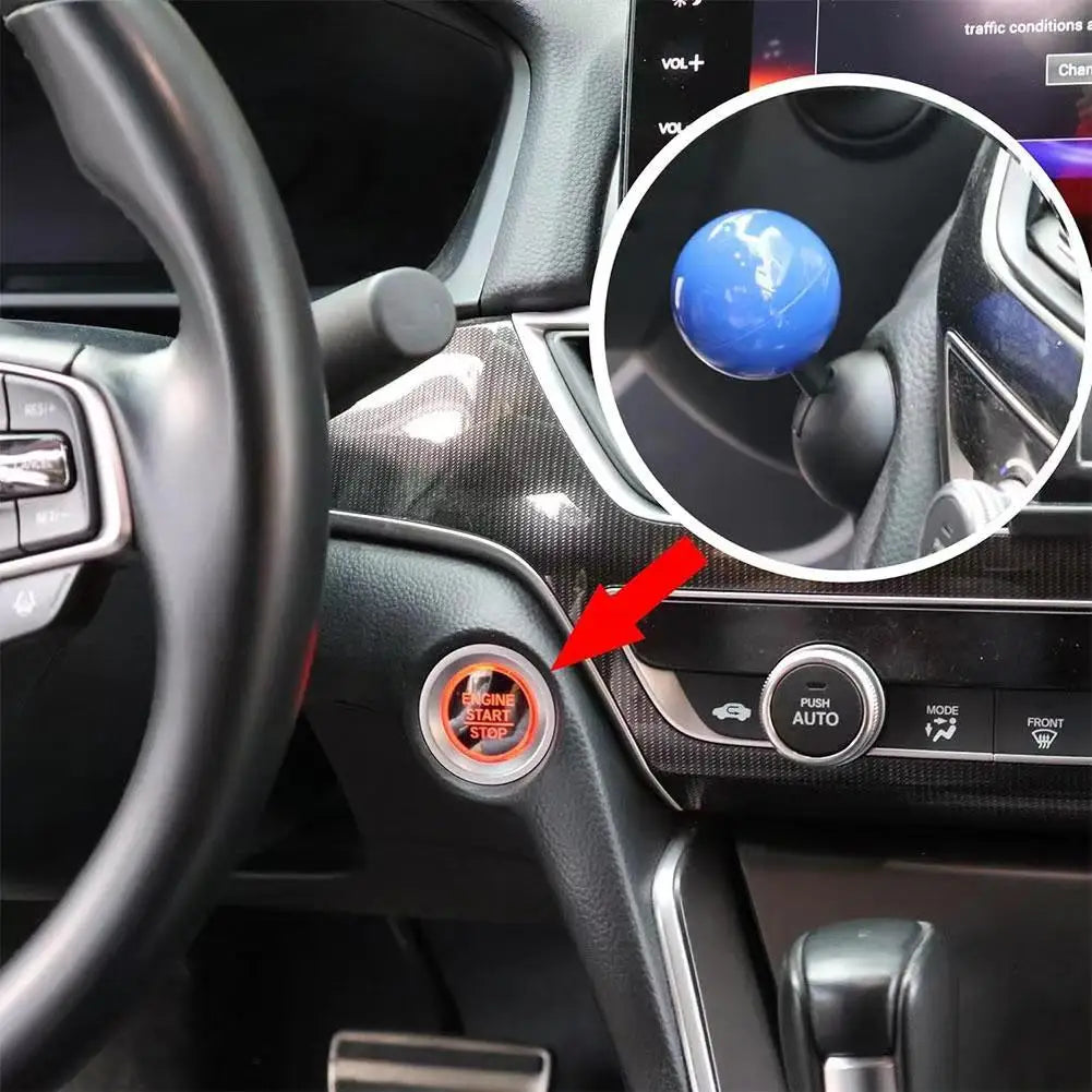 Close-up of a push start ignition button cover on a car steering wheel and dashboard.