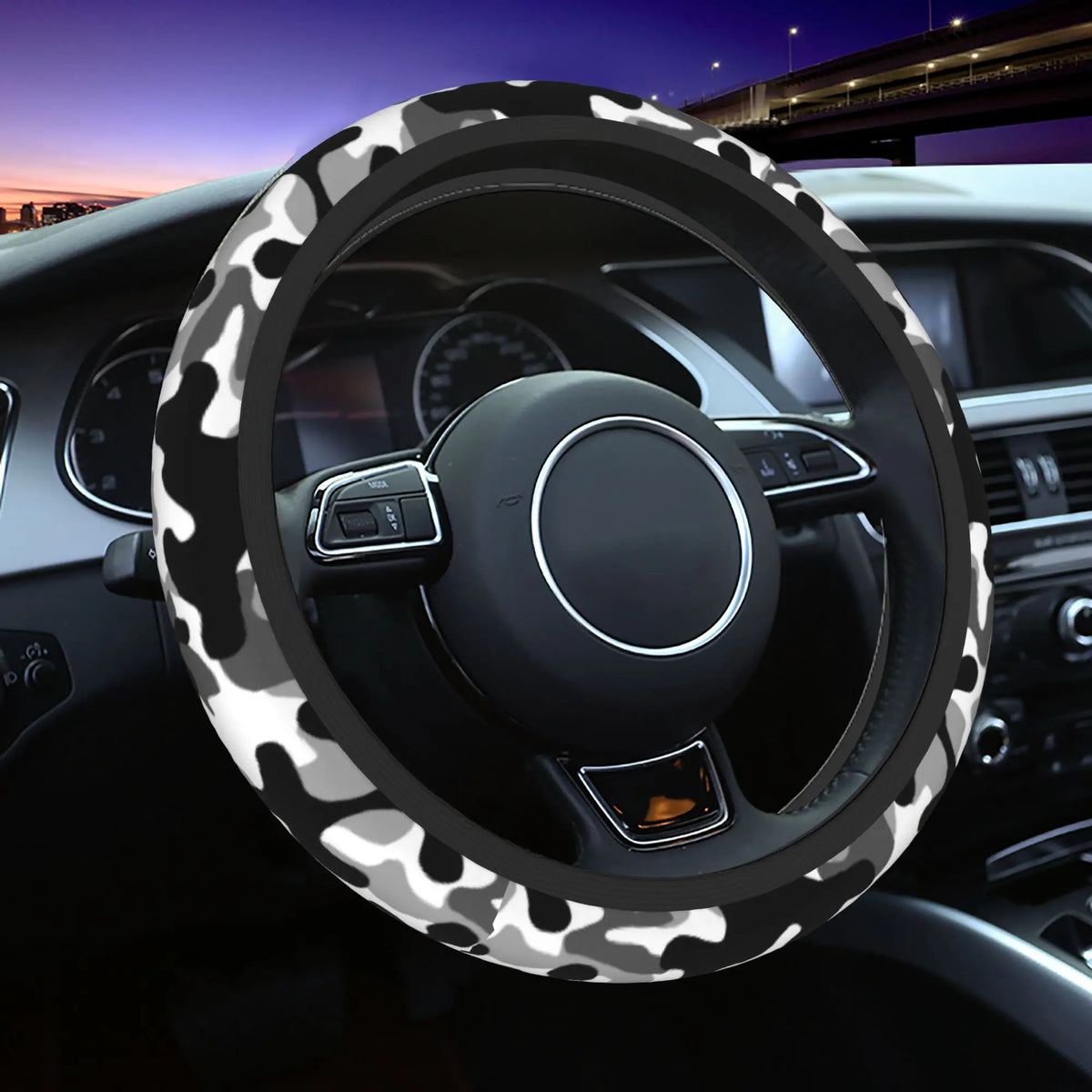 Schwarzes Lenkrad mit weiß-grauer Tarnmuster in der Auto-Innenausstattung.