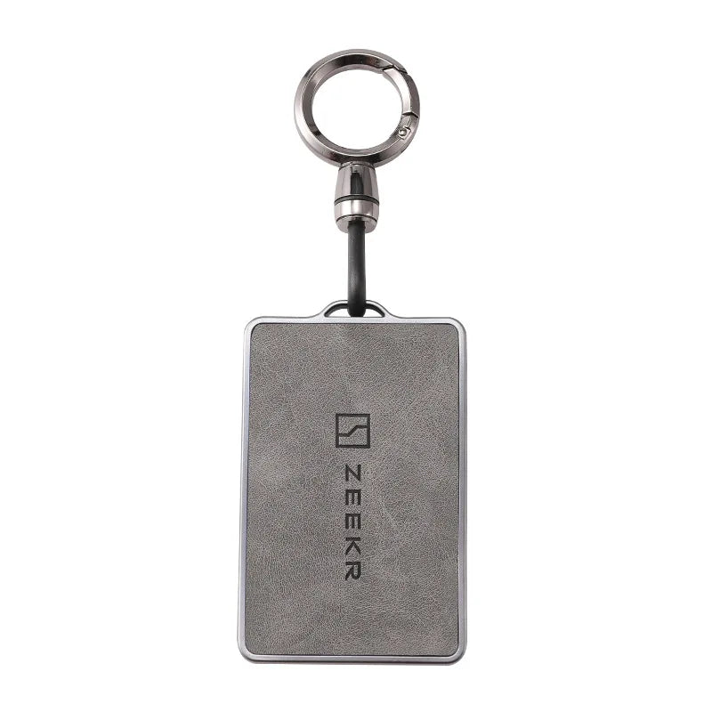 Housse de clé NFC argentée avec porte-clés et étiquette métallique rectangulaire.