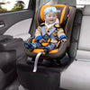 A baby wearing a light blue knitted cap and a yellow jacket is seated in a brown car seat protector with an orange harness.