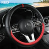 A black steering wheel with red stitching and a silver accent is shown inside a car cabin.