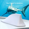 A white shark fin antenna decoration is shown against a blue background.