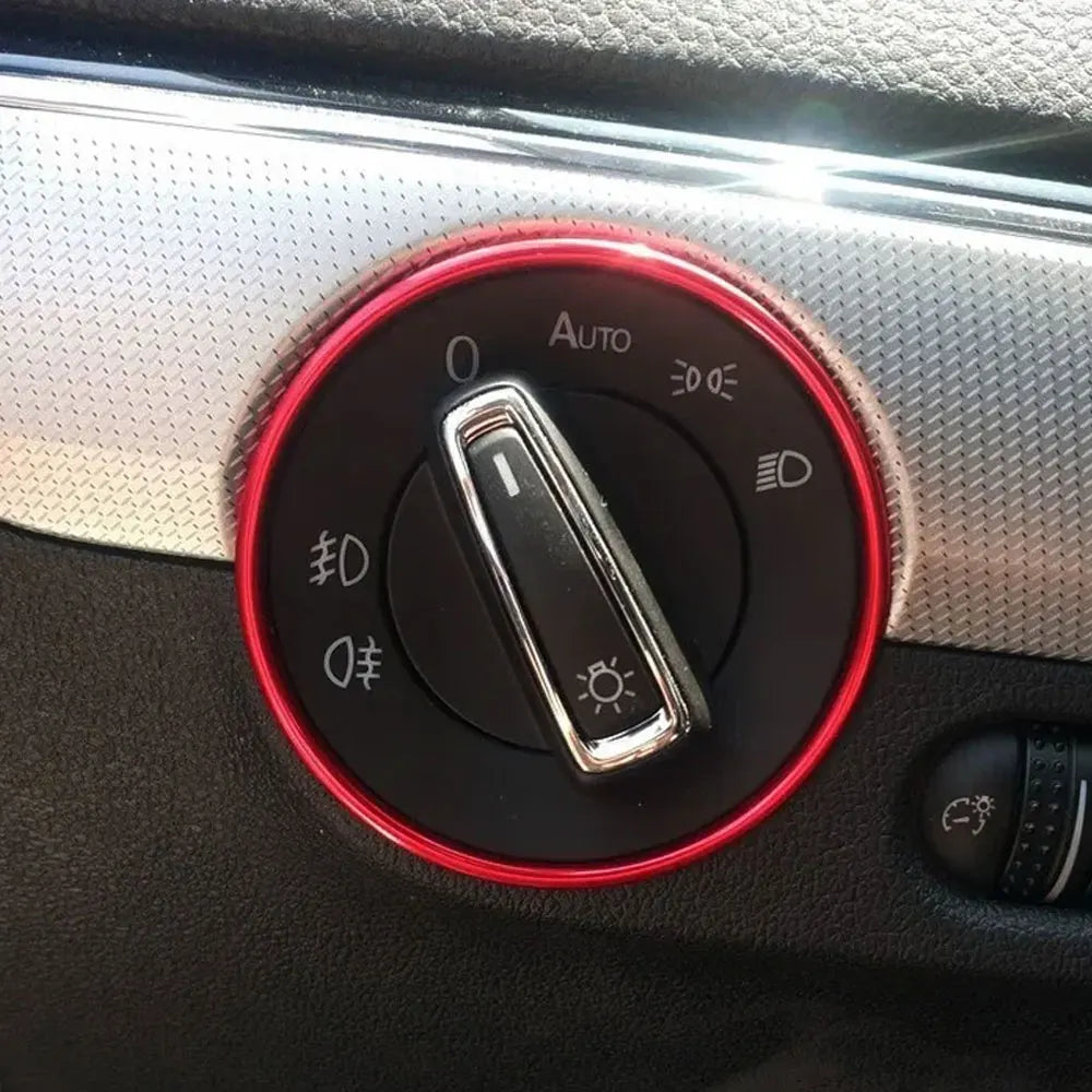 Nahaufnahme eines runden roten Zierrings mit einem Auto-Modus-Wechselschalter auf einer Armaturenbrett-Oberfläche eines Autos