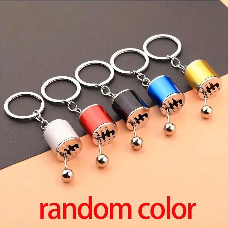 A set of random color creative car modification keychains with silver rings and metal charms displayed on a neutral backgroun