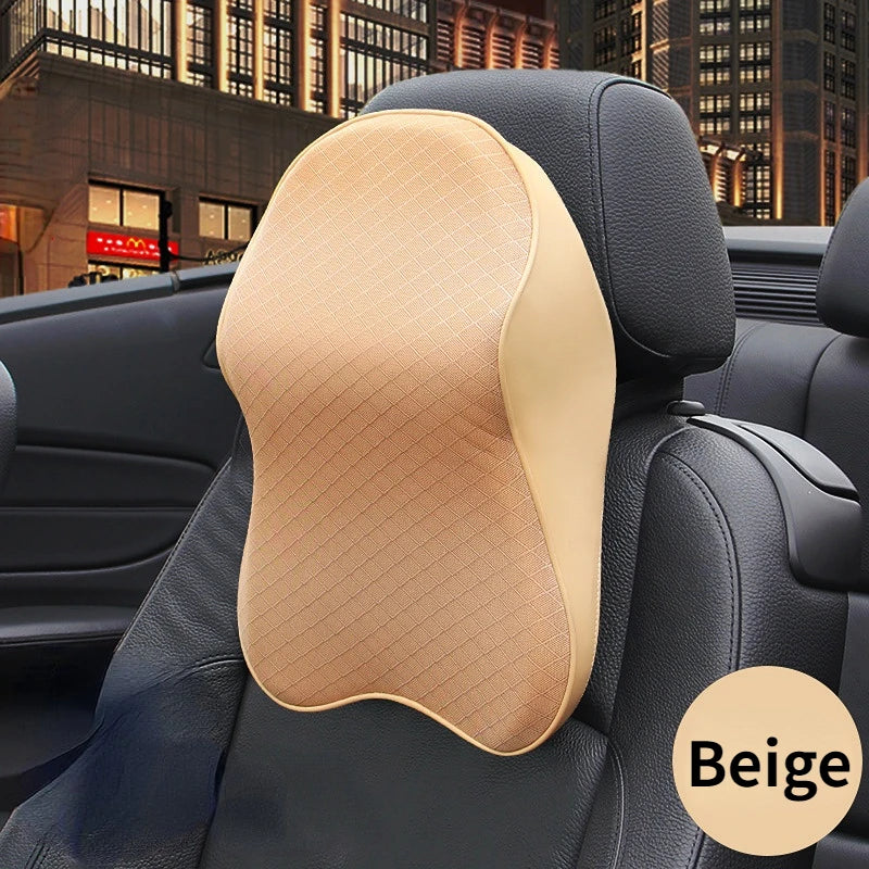 A beige ergonomic headrest pillow for neck and lumbar support placed on a black car seat.