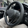Nahaufnahme eines schwarzen Lenkrads mit Bedienelementen und einer Leder-Lenkradabdeckung im Auto-Innenraum.