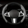 A close-up view of a black steering wheel with silver accents and an airbag cover.
