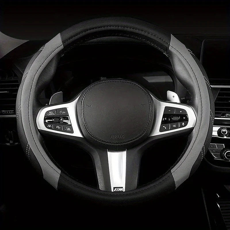 A close-up view of a black steering wheel with silver accents and an airbag cover.