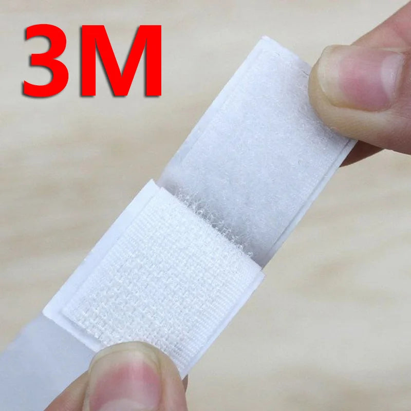A hand is holding a white 3M hook and loop tape strip, showing its texture and thickness.